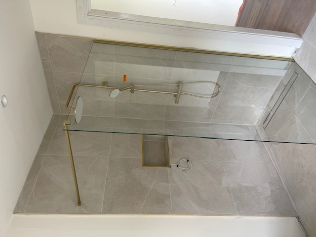 Walk-in shower with brushed gold fittings
